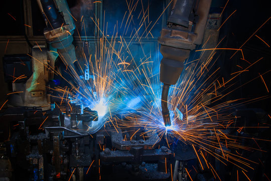 Team robots welding automotive part