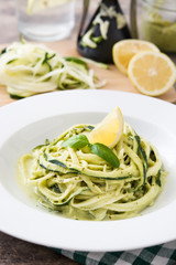 Zucchini noodles with pesto sauce on wooden table

