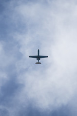 A plane flying in the blue sky with white clouds