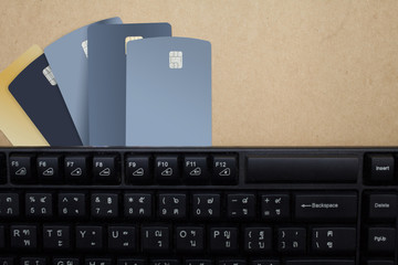 Credit card,book bank,keyboard and plant at brown background topview