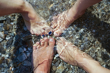 Familie mit vier Füßen im Wasser