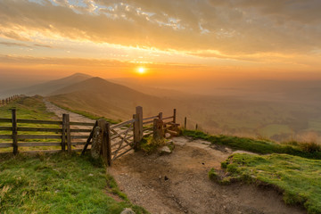 Golden sunrise at Mam Tor in the English Peak District on a hazy Autumn Morning with wooden gate. © _Danoz