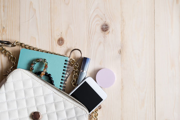 Top view of Women bag and lady stuff with copyspace on wooden background