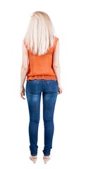 back view of standing young beautiful  blonde woman. she shyly looks at something. girl  watching....