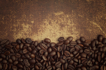 Dark roasted coffee beans on shabby chic surface