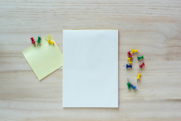 Open notebook and sticky note on wooden background.