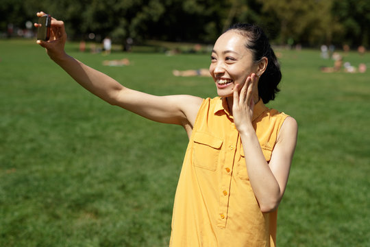 Asian woman in a city park talking selfie photo