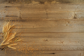wheat ears with grains on the wooden background