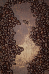 Dark brown roasted coffee beans on a shabby chic surface