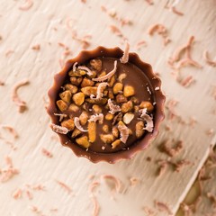 Top view on chocolate cupcake with nuts and shavings around