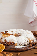 Christmas stollen and spices on wooden background