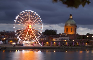 Big wheel at night with lights and the dome, Toulouse, France