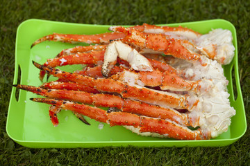 Boiled leg of the royal king crab on a green tray