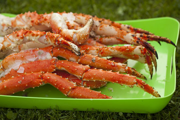 Boiled leg of the royal king crab on a green tray