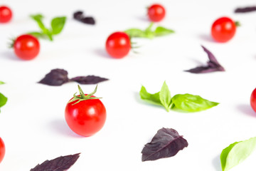 Colorful pattern made of cherry tomatoes, purple and green basil on white background. Cooking concept.