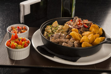 portion of meat with fries and fried yucca