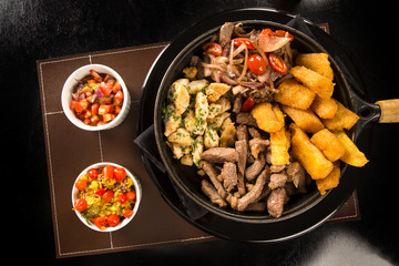 portion of meat with fries and fried yucca
