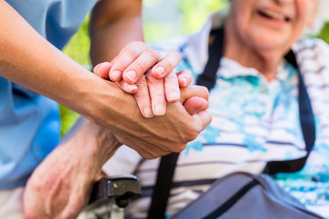 Infirmière consolant une femme âgée tenant sa main