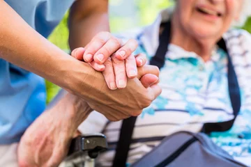Deurstickers Zorgcentrum Verpleegkundige troost senior vrouw die haar hand vasthoudt