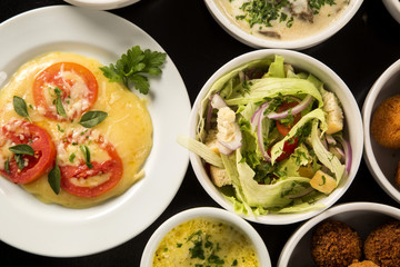 Mixed brazilian snacks, including pastries, fried chicken, salad