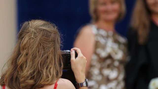 Young woman using camera to take picture at university graduation ceremony