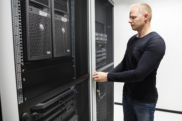 Computer Engineer Opening Server Rack Door In Data Center