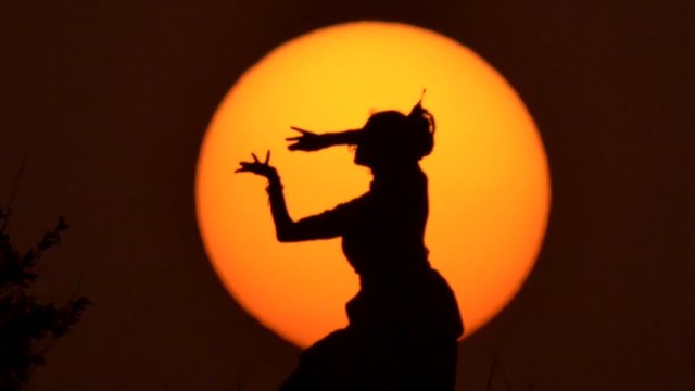 Silhouette girl oriental dancer a dance on sunset