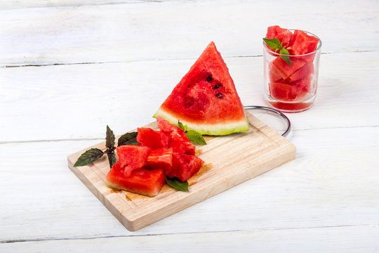 still life of red watermelon slices on a wooden tray with a white background