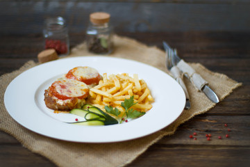 Meat baked with cheese and tomato served with fries