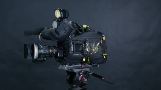 Professional digital video camera, camcoder isolated on black background in tv srudio. 4K.
