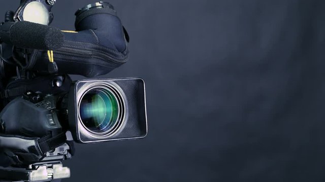 Movement along professional studio camera, camcoder standing in TV studio ready for broadcasting. 4K.