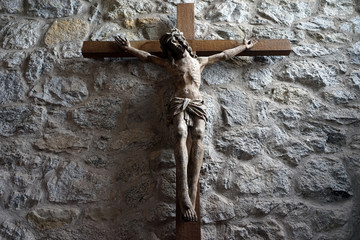 Wooden crucifix on the stone wall - obrazy, fototapety, plakaty