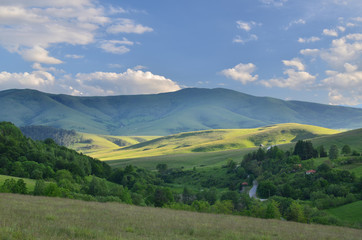 Fototapeta na wymiar Landscape of Zlatibor Mountain. Green meadows and hills under blue sky with some clouds