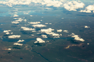 Naklejka na ściany i meble Aerial view of clouds over the land, the landscape. The texture of the scenic sky and the world. 