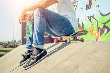 Skateboarder sit rest on skatepark