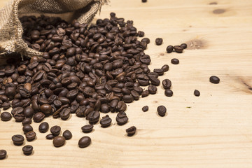 Coffee beans in an old bag on a wooden table