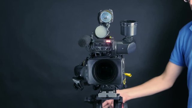 Studio camera. Cameraman turns professional camera, ready for shooting. 4K