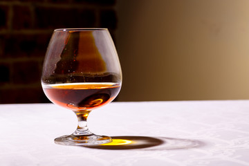 The glare from the glass of French brandy reflected on white tab