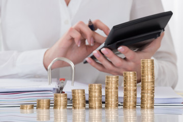 Close-up Of Businesswoman Calculating Invoice