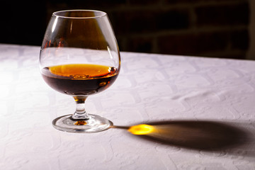 The glare from the glass of French brandy reflected on white tab