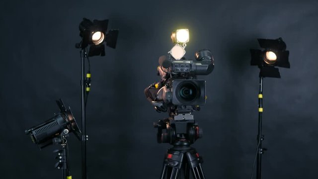 Professional digital video camera, camoder isolated on black background in tv srudio. 4K.