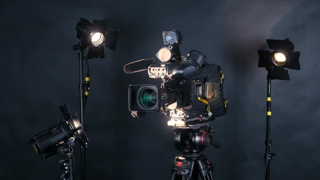 Professional digital video camera, camoder isolated on black background in tv srudio. 4K.
