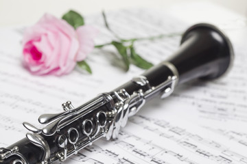 Clarinet with red  rose on sheet music