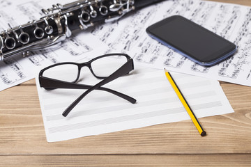Musical notes and clarinet on wooden table