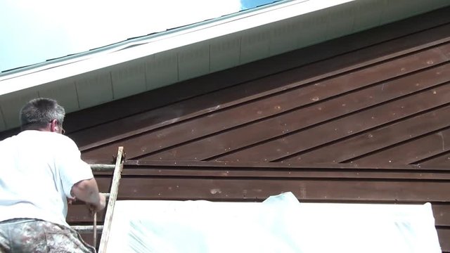 Guy Spraying Stain - Brushing Into Wood