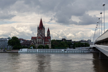 Vienna, Austria 3.06.2016 Cruise ship on Danube with St. Francis of Assisi Church on a cloudy day