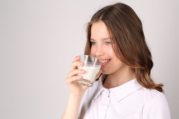 Girl in drinking milk. Close up. White background