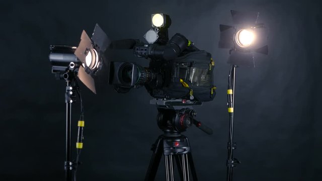 Camcorder, video camera and professional studio lights in a broadcasting studio. 4K.