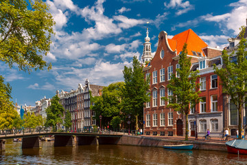Naklejka premium Amsterdam canal, bridge, church and typical houses in the sunny summer day, Holland, Netherlands.