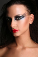 Girl with smokey eyes and wild hair. Close up. Black background